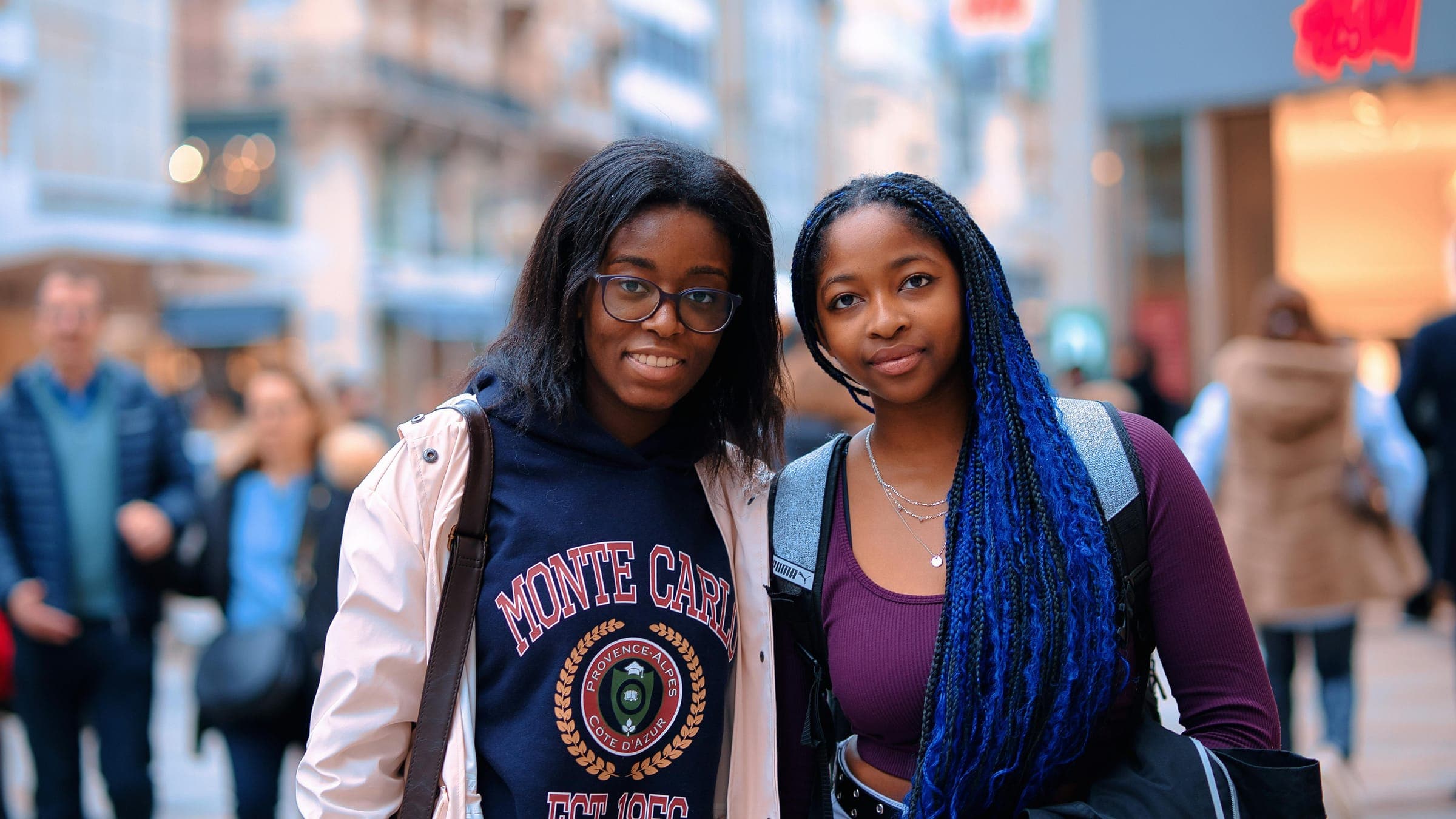 Two students smiling on a busy city street in Europe