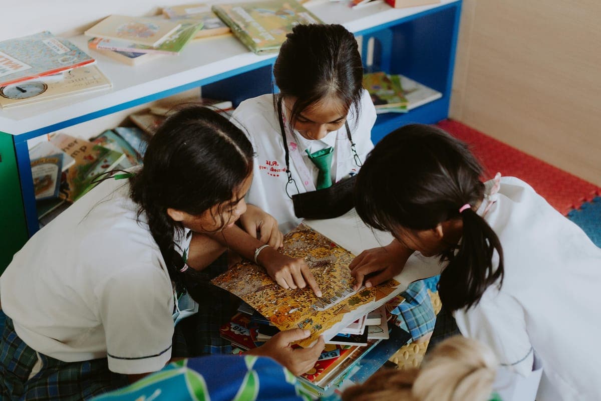 Students in school uniform reading a picture book together