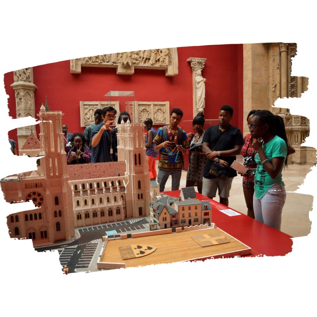 Students photographing architectural models of a cathedral in a museum gallery