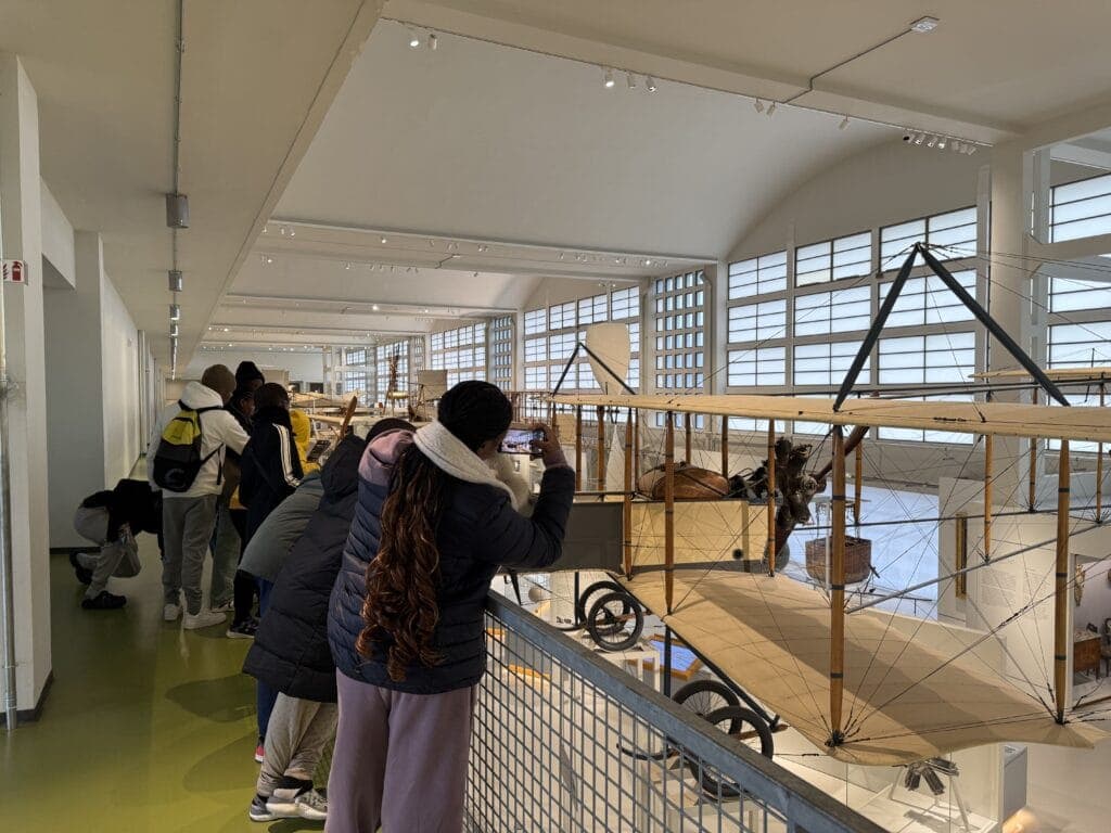 Students on a school trip looking at exhibits in a museum