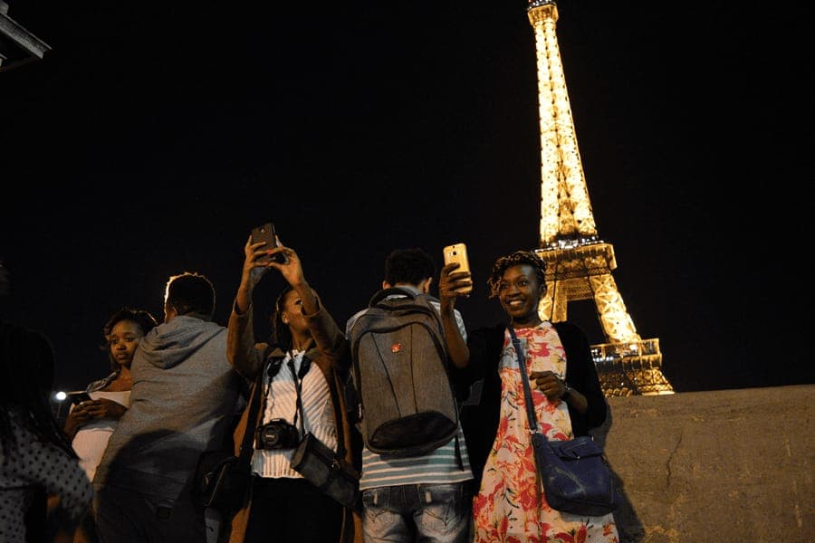 Students photographing the Eiffel Tower lit up at night