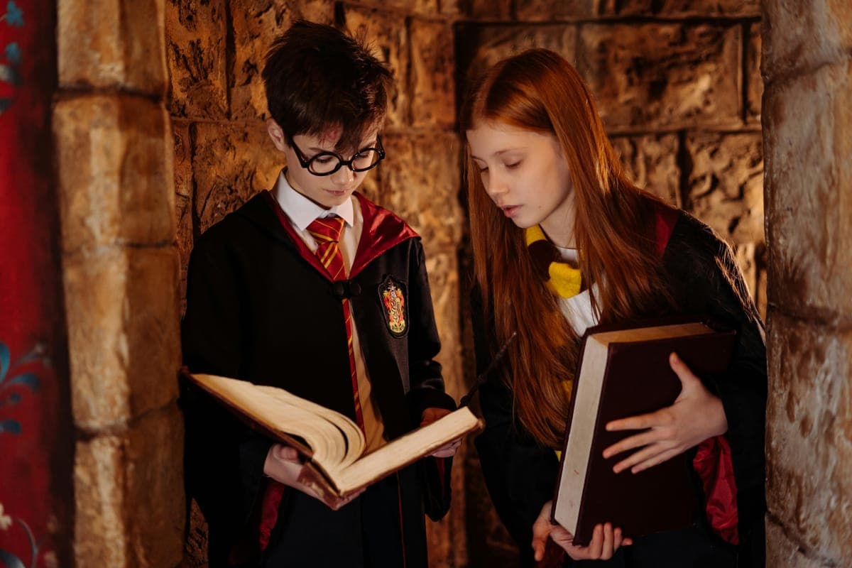Young people in Harry Potter costumes reading old books