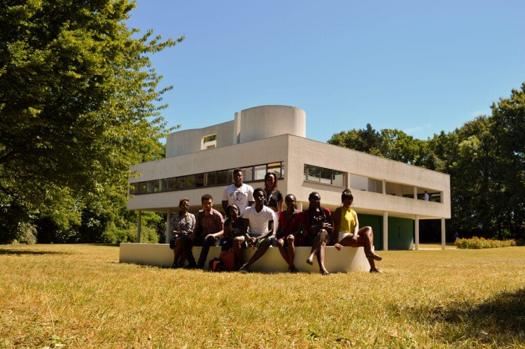 A student group sitting outside Villa Savoye by Le Corbusier