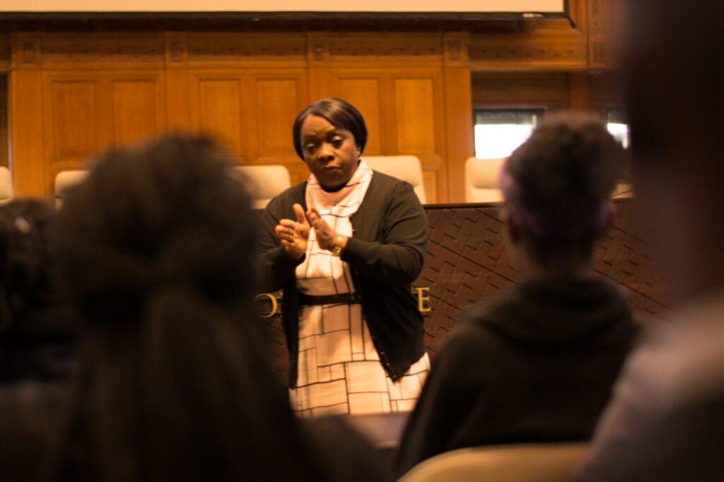 A speaker addressing students in a wood-panelled courtroom