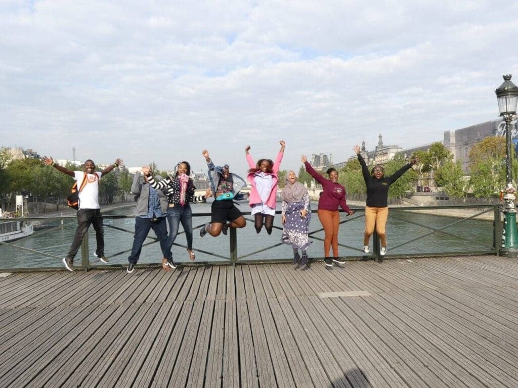 Students jumping in the air on a bridge over the Seine in Paris