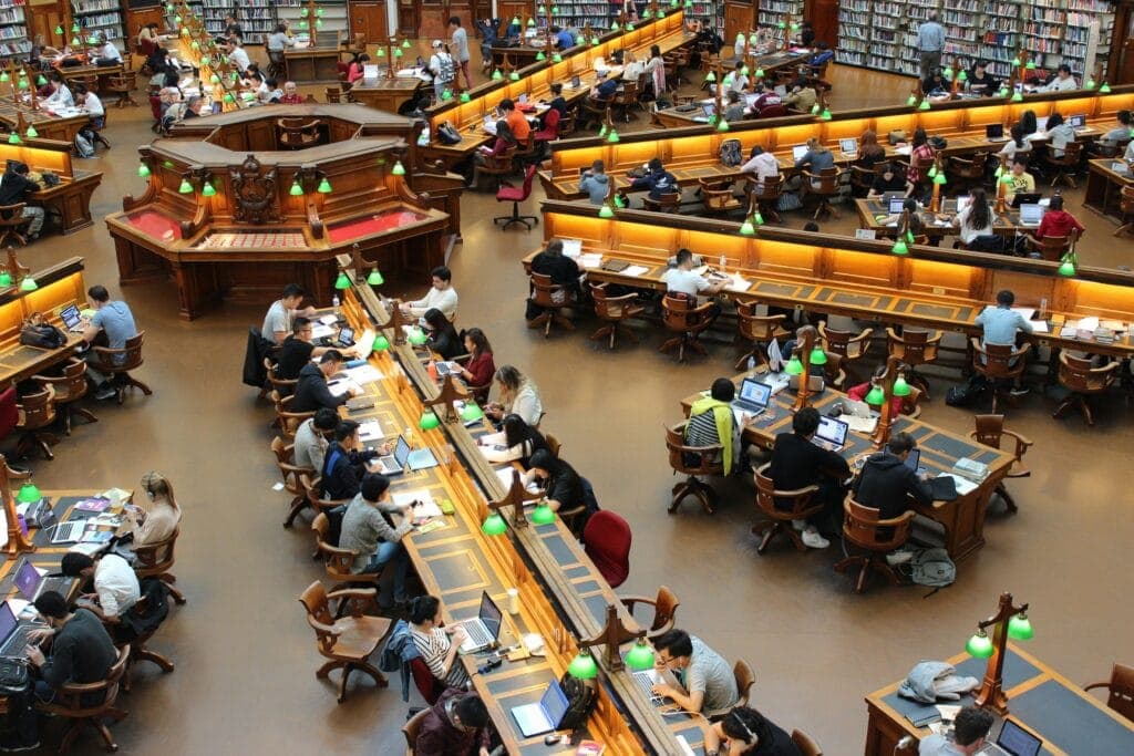 Students working at desks in a grand library reading room