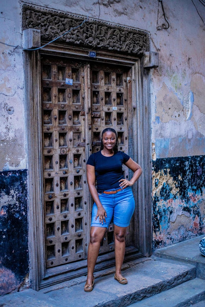 A ReadTrips traveller beside a carved Swahili door in Zanzibar